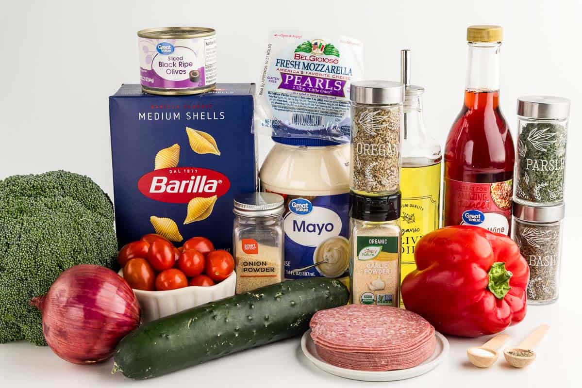 Creamy pasta salad ingredients on a white countertop.
