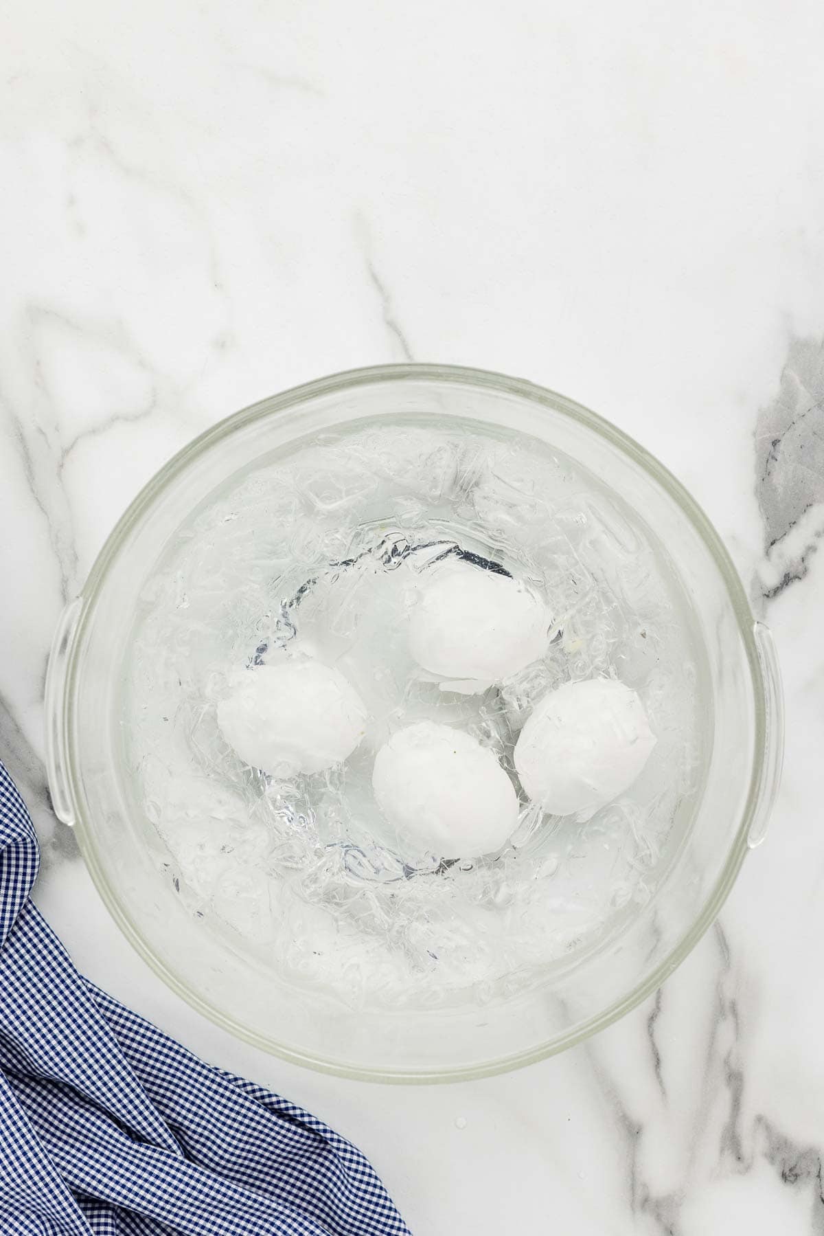Eggs submerged in a bowl of ice and water.