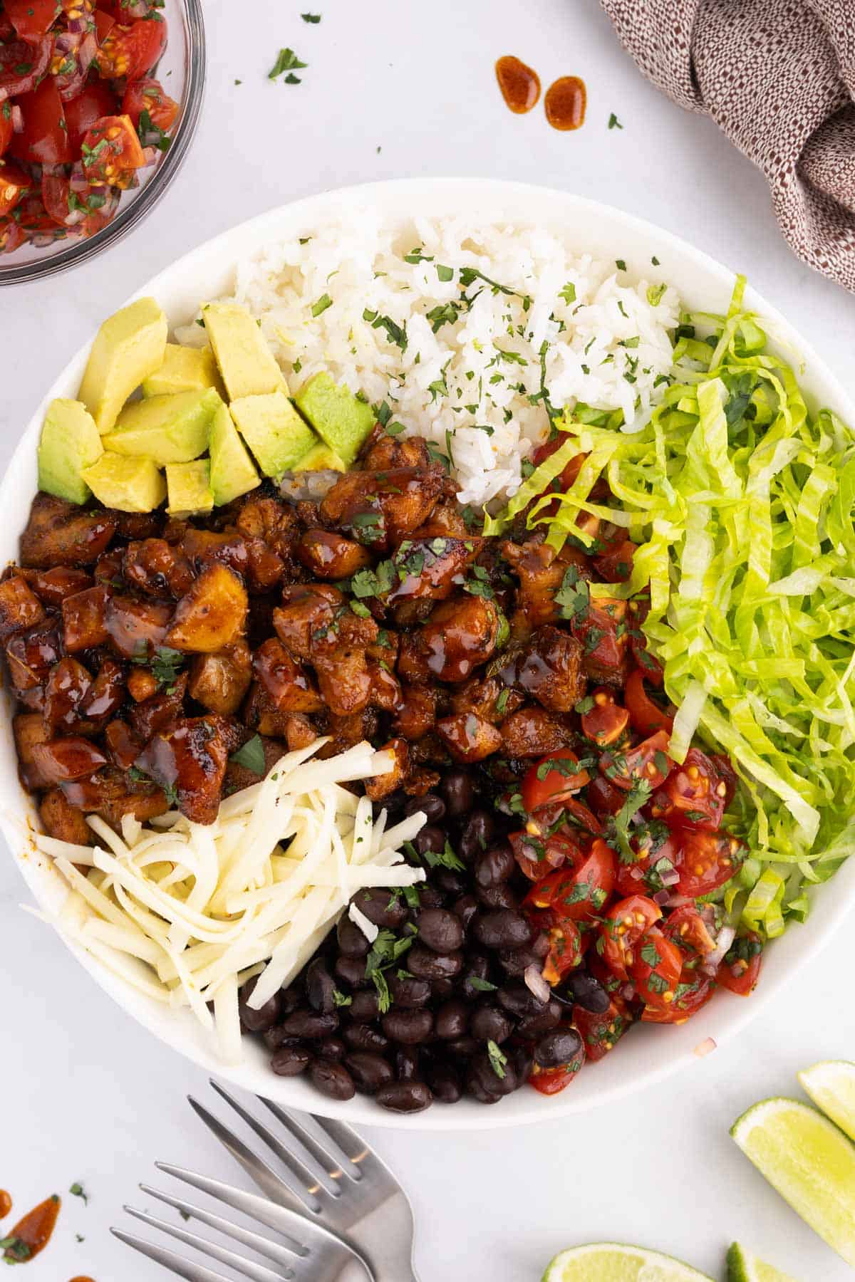A bowl of honey chicken with piles of toppings.
