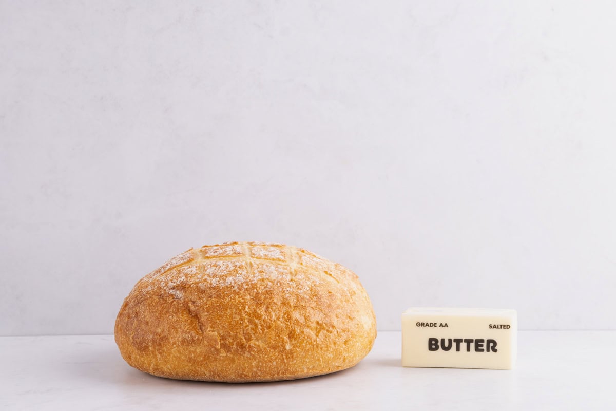 Bread and butter on a white countertop.
