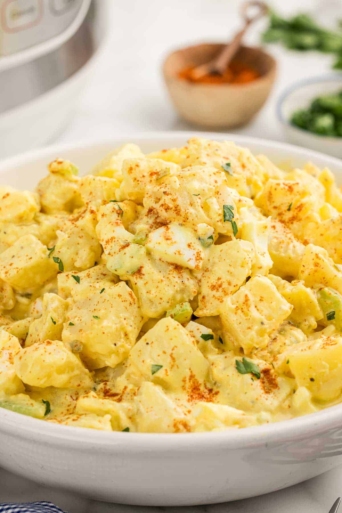 Potato salad in a white serving bowl.