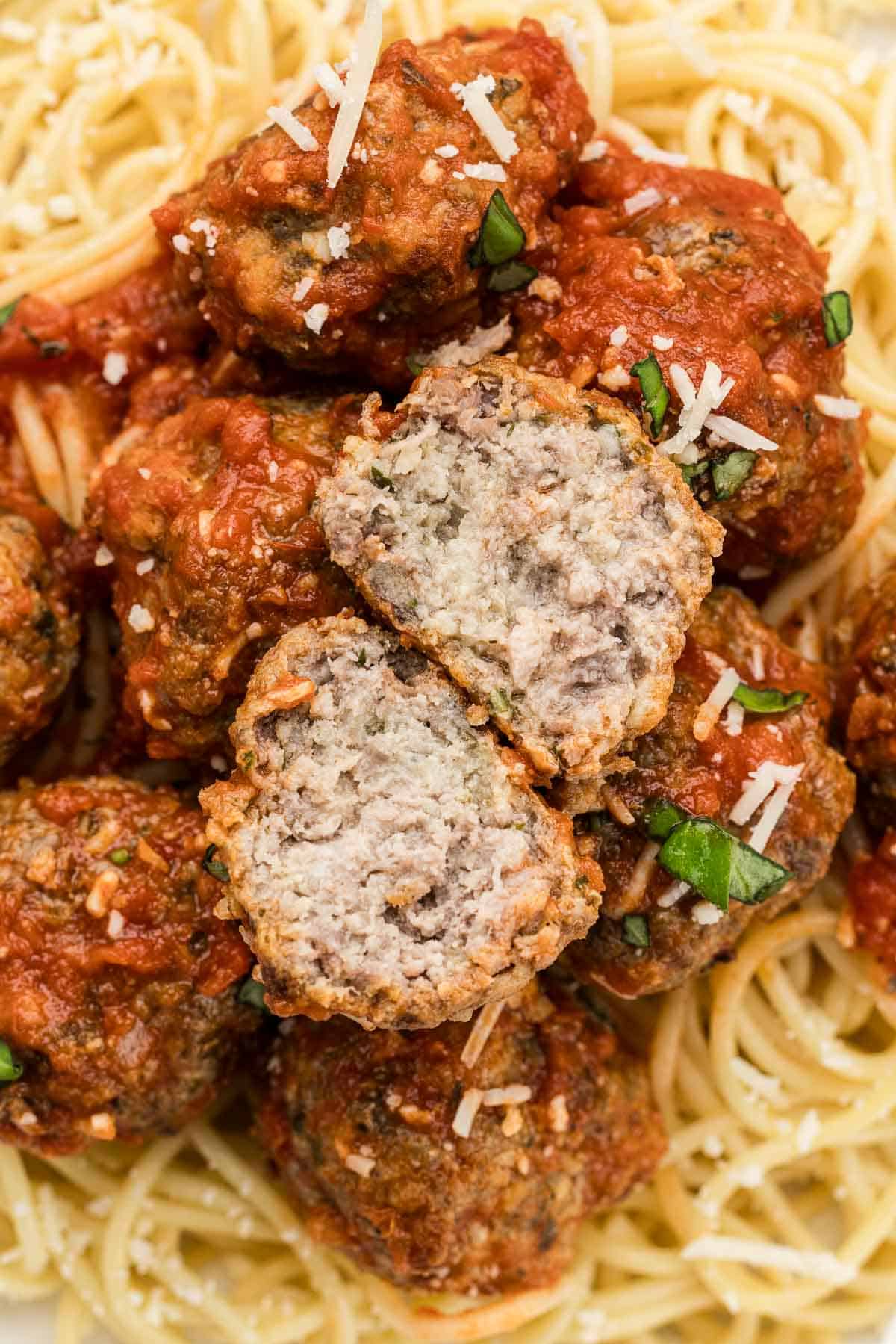 A meatball on spaghetti that's cut in half.