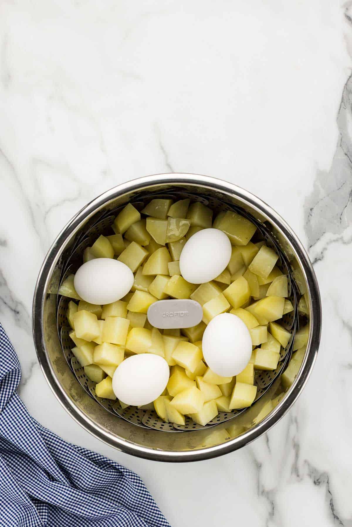 Eggs added to an instant pot full of potatoes.
