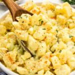 A wooden spoon scooping up a bite of potato salad.