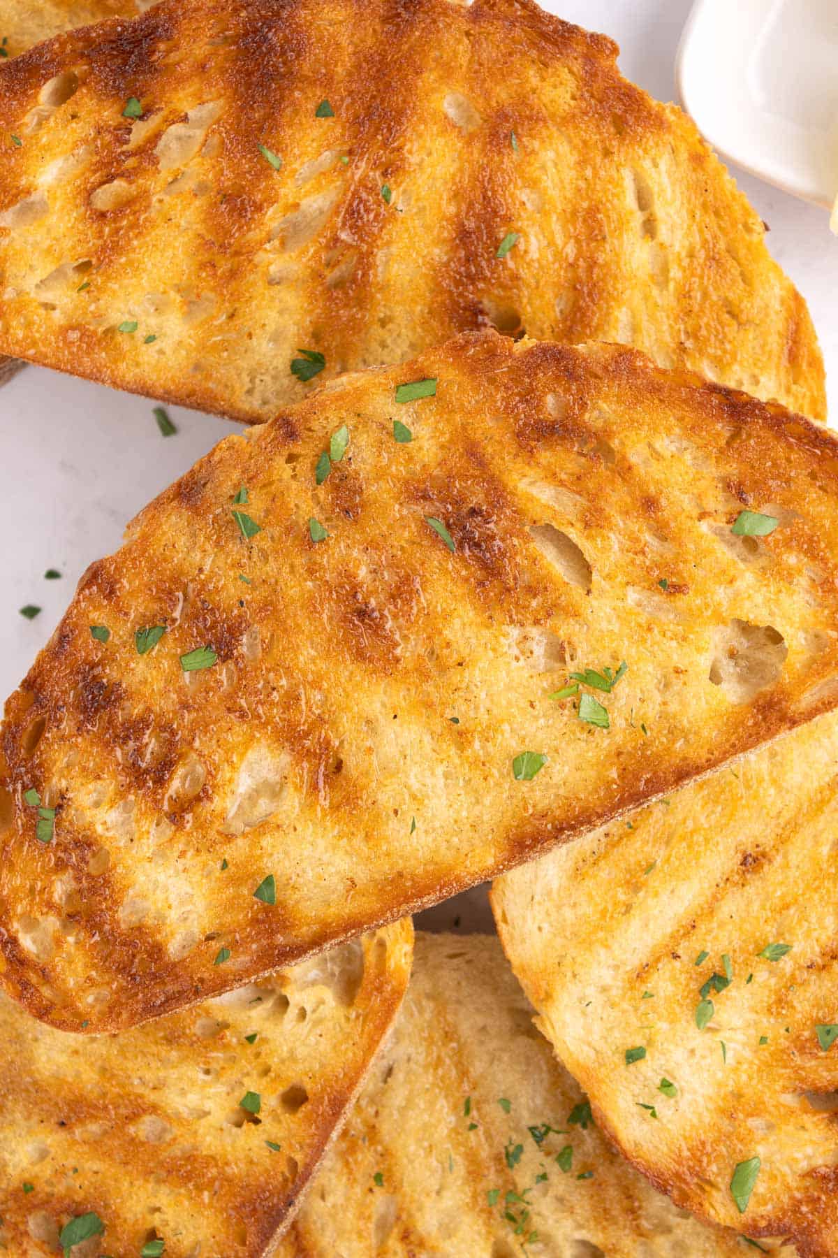 A bread slice stacked on top of a pile of more slices.