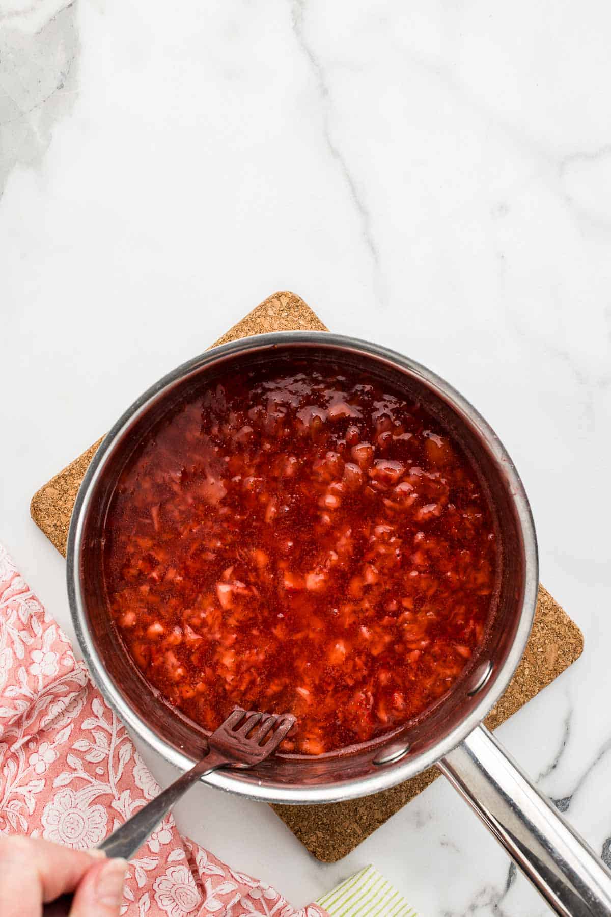 Sauce in a cooking pan with a fork.