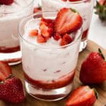 A cup of strawberry mousse with fresh berries on top.