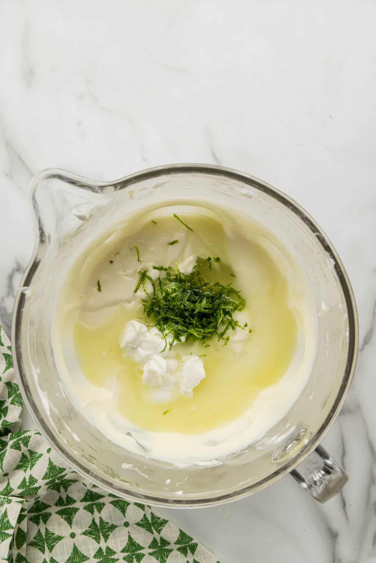 Key lime cheesecake ingredients in a glass measuring cup.