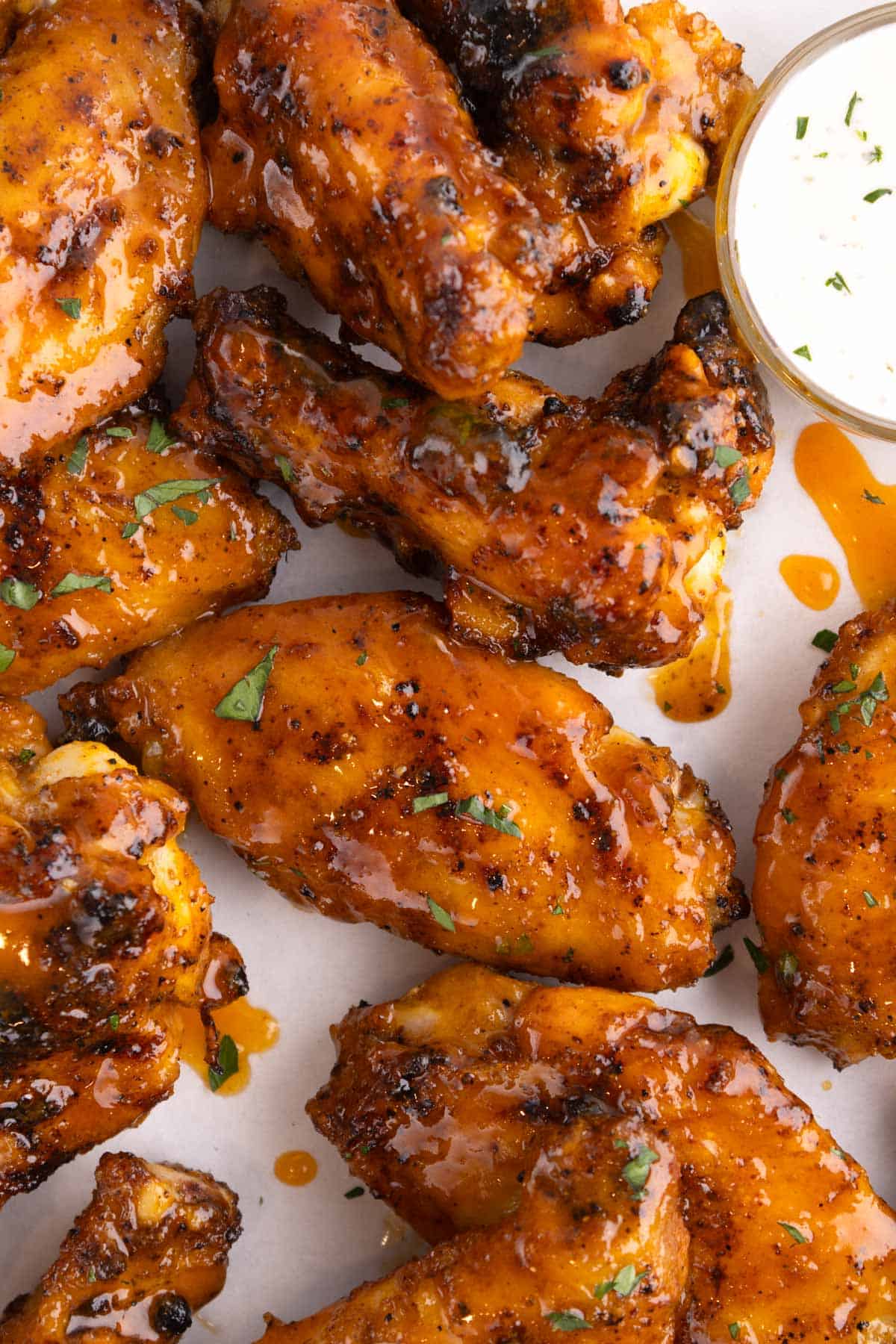 Closeup of wings doused in sauce in a clump together.