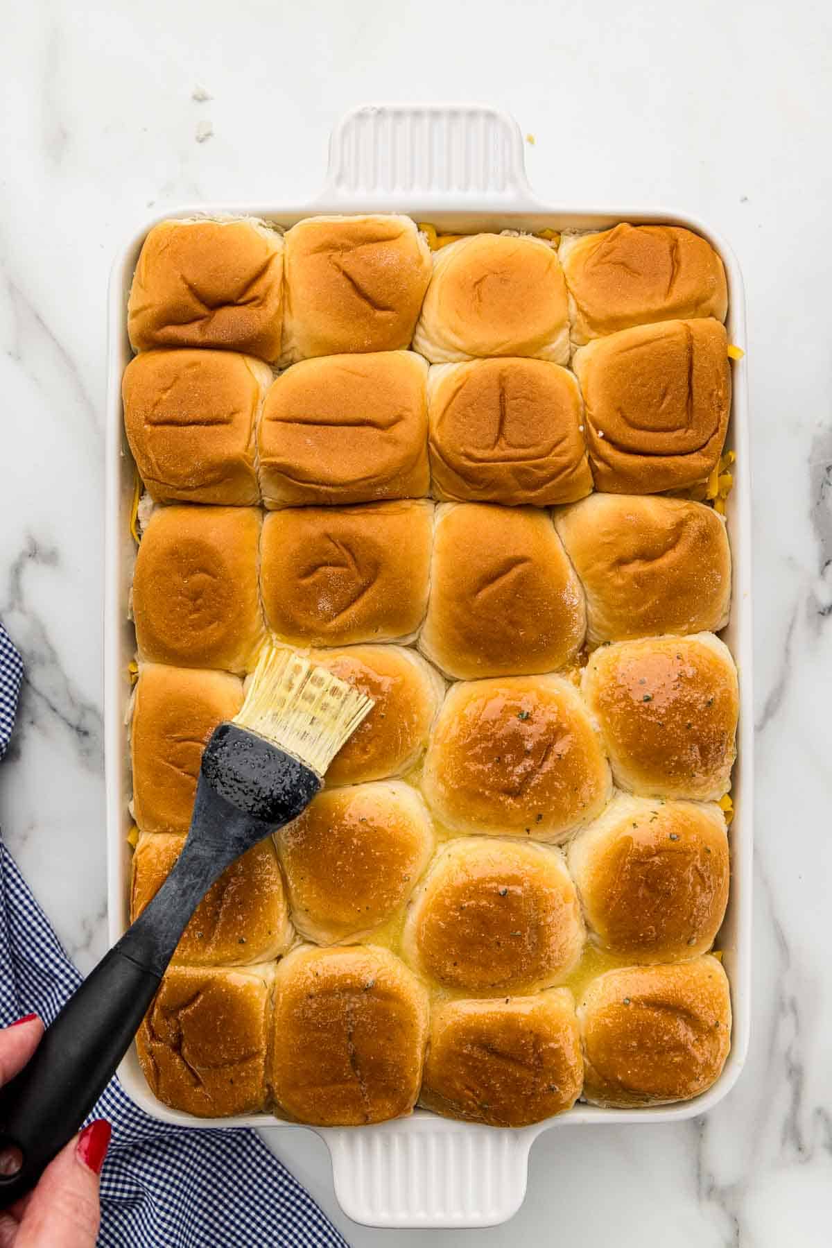 Buns being coated with a silicone brush.