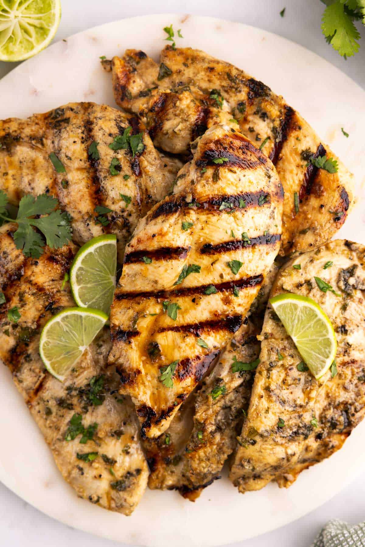 A plate of cilantro lime chicken with lime slices.