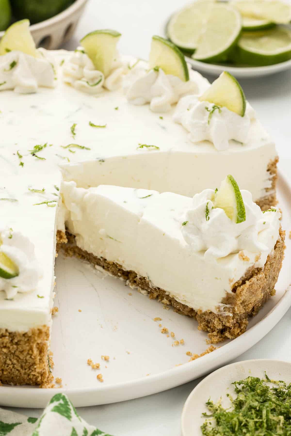 A sliced no bake lime cheesecake on a white serving plate.