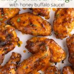 Wings covered in sauce on parchment with a graphic overlay.
