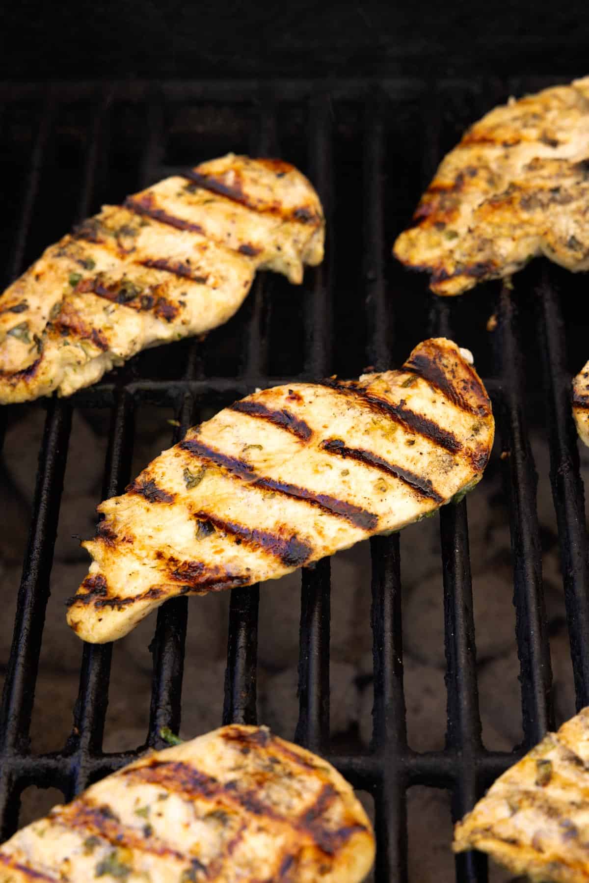 Cooked chicken sitting on a grill.