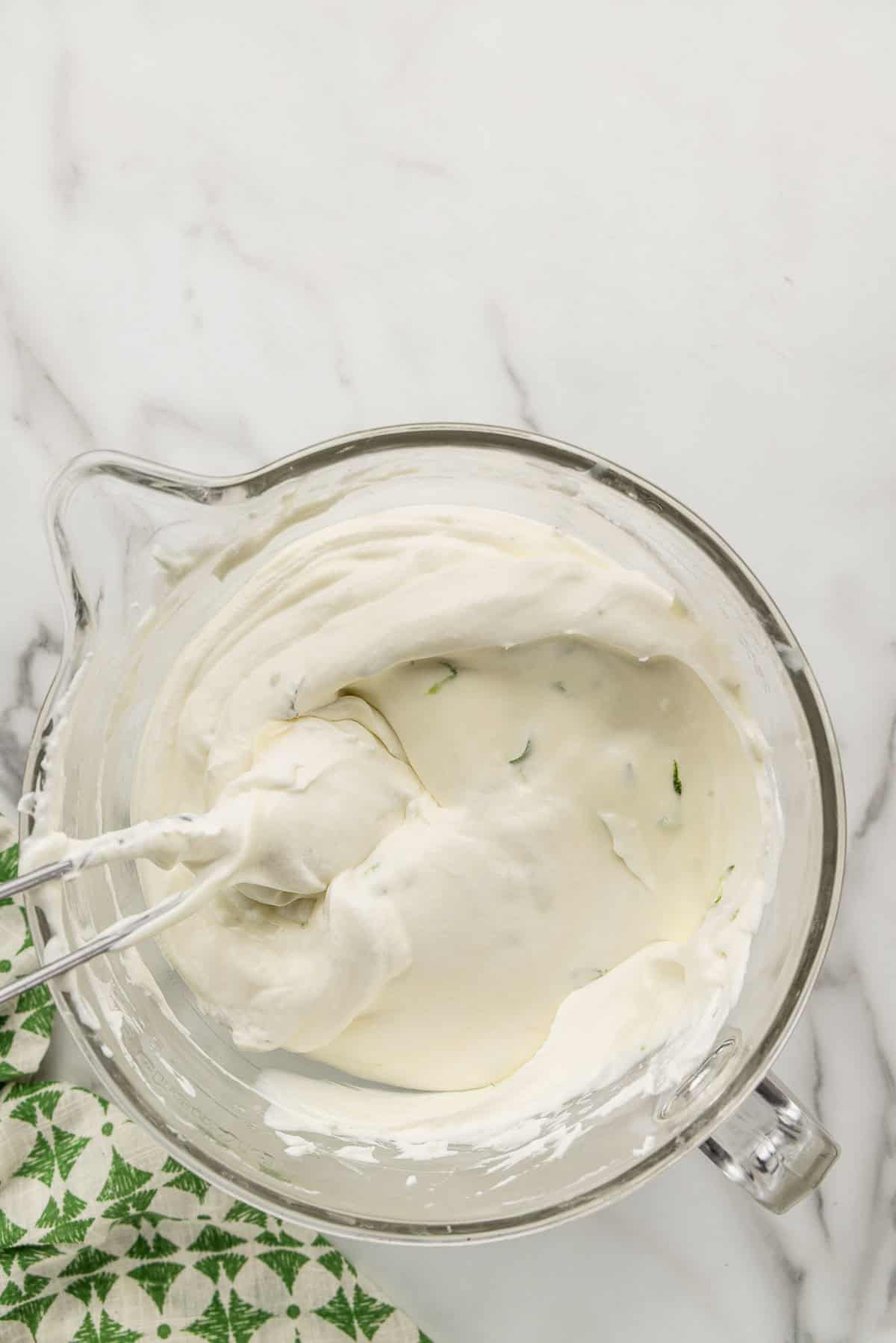 Cheesecake batter mixed with a rubber spatula in a dish.