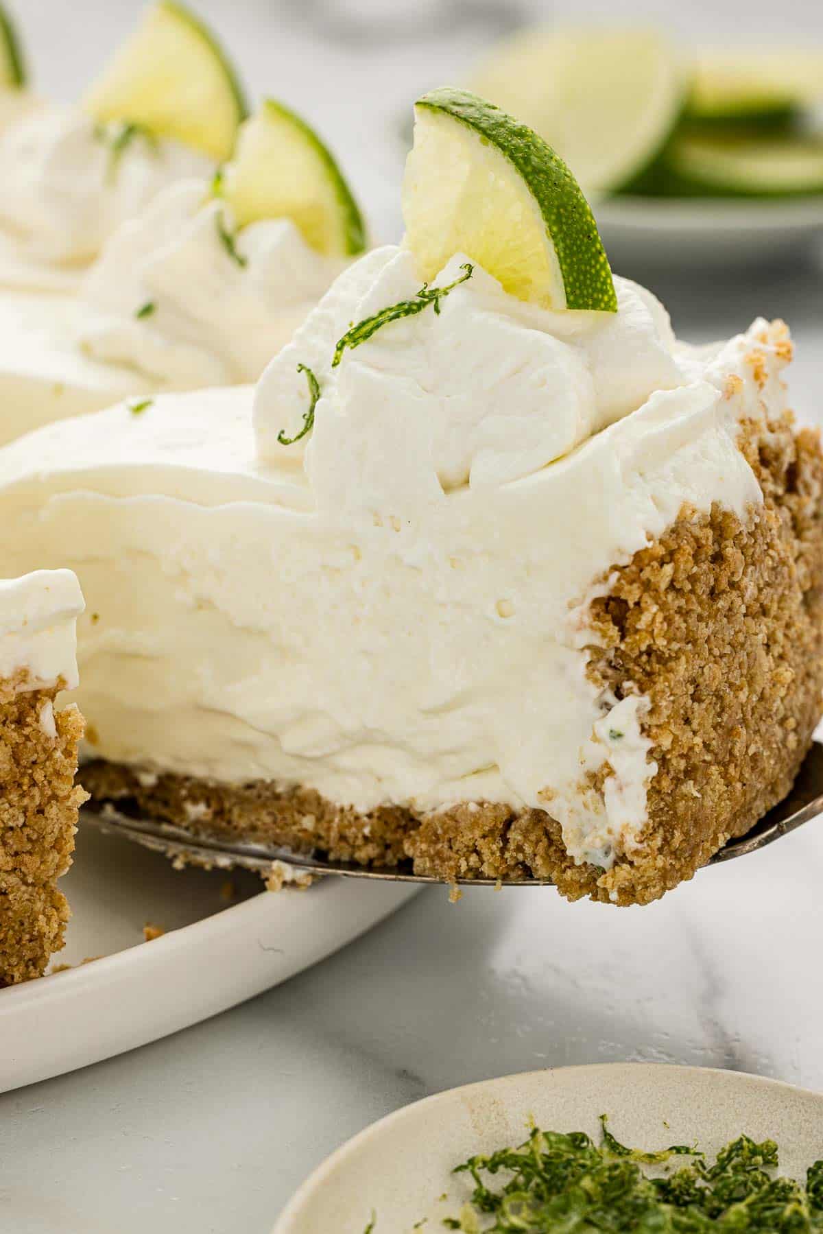 A slice of lime cheesecake on a serving spatula.