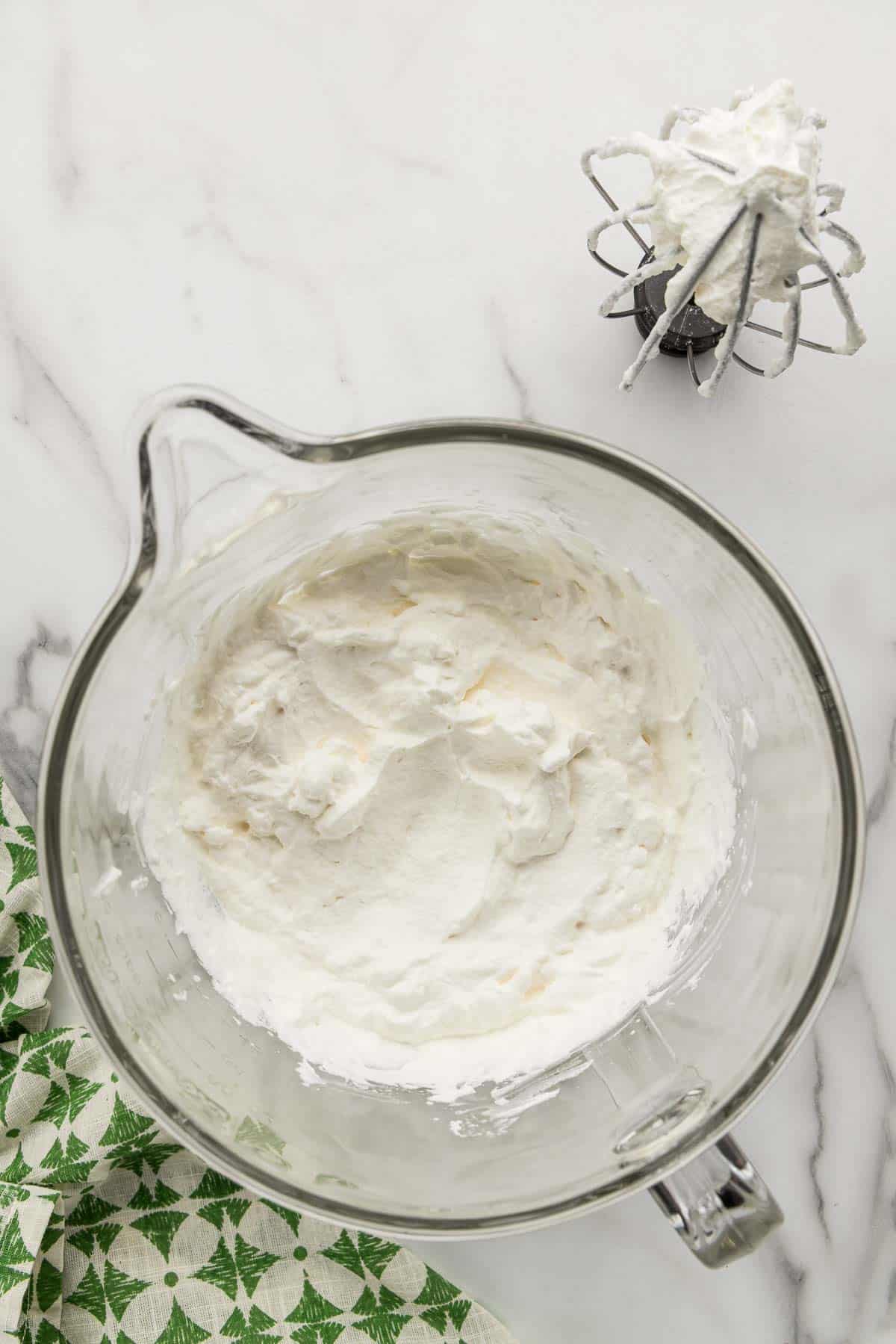 Whipped cream blended in a glass measuring cup.