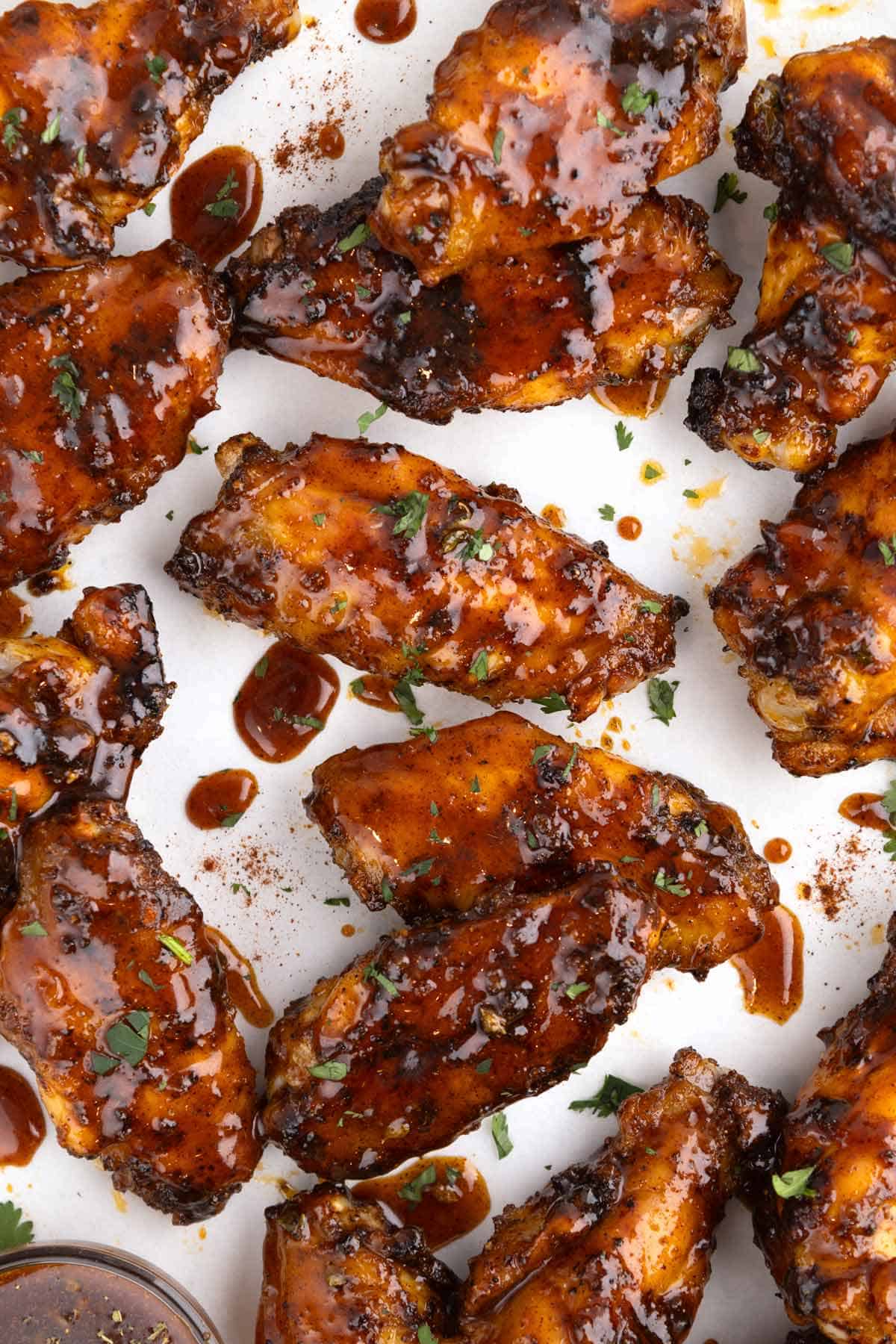 A cluster of honey chipotle wings on parchment paper.