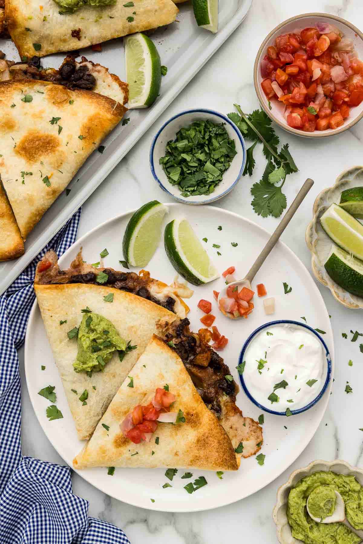A serving of quesadillas topped with salsa and guacamole.