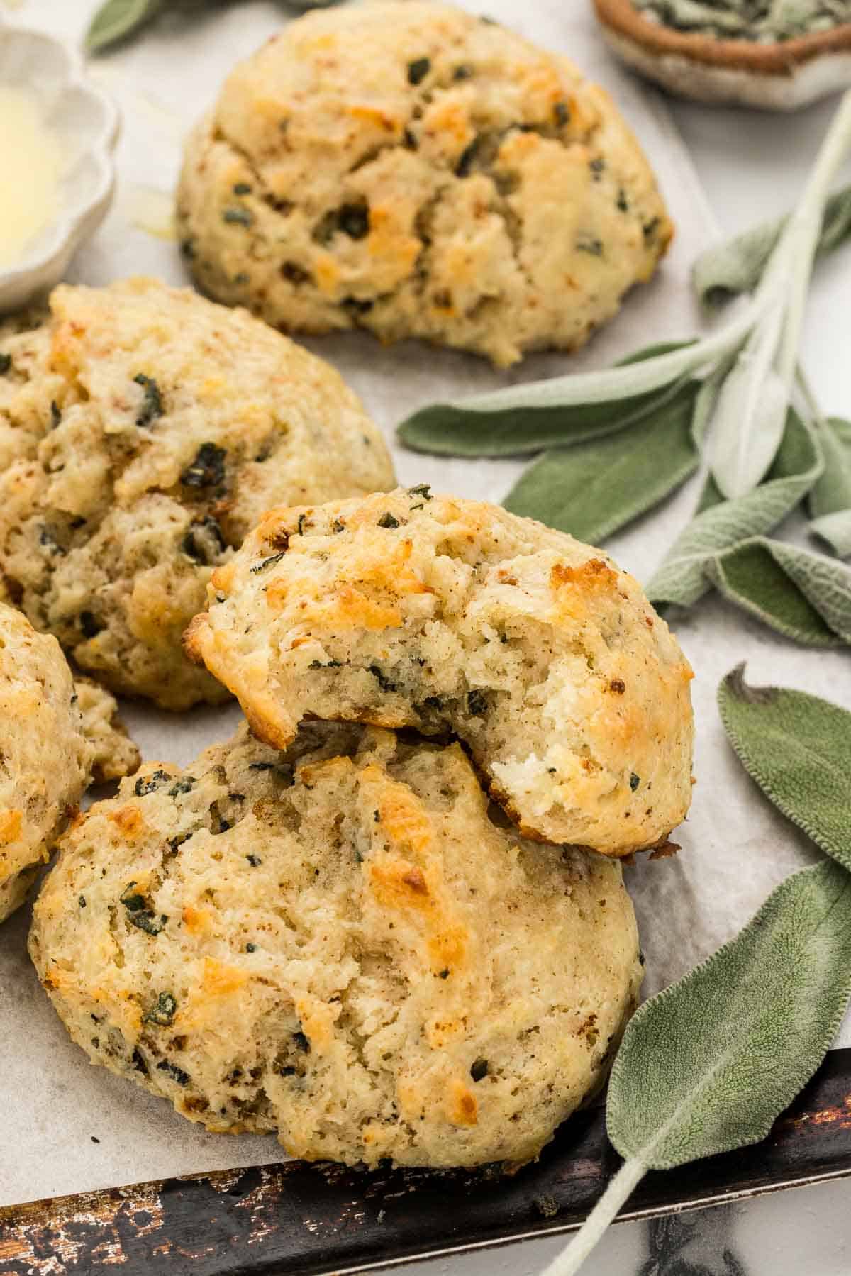 A pile of sage biscuits with a bite taken out of one of them.