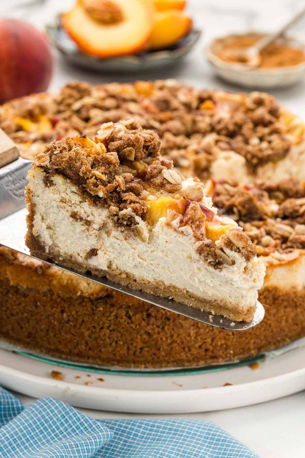 Closeup of a slice of peach cheesecake on a serving spatula.