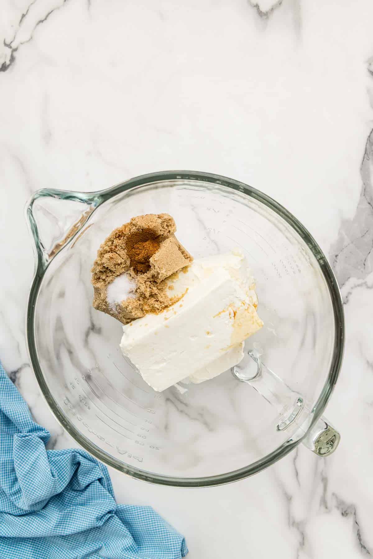 Cheesecake ingredients unmixed in a glass measuring dish.