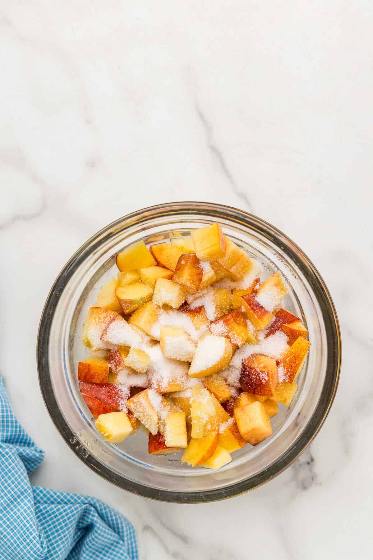 Peaches and sugar in a mixing glass.