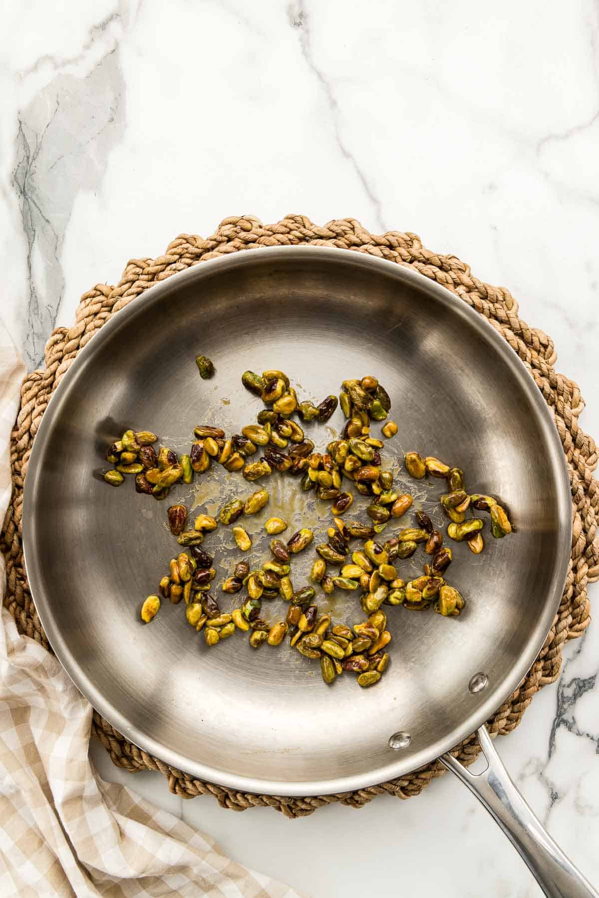 A skillet of cooked pistachios.