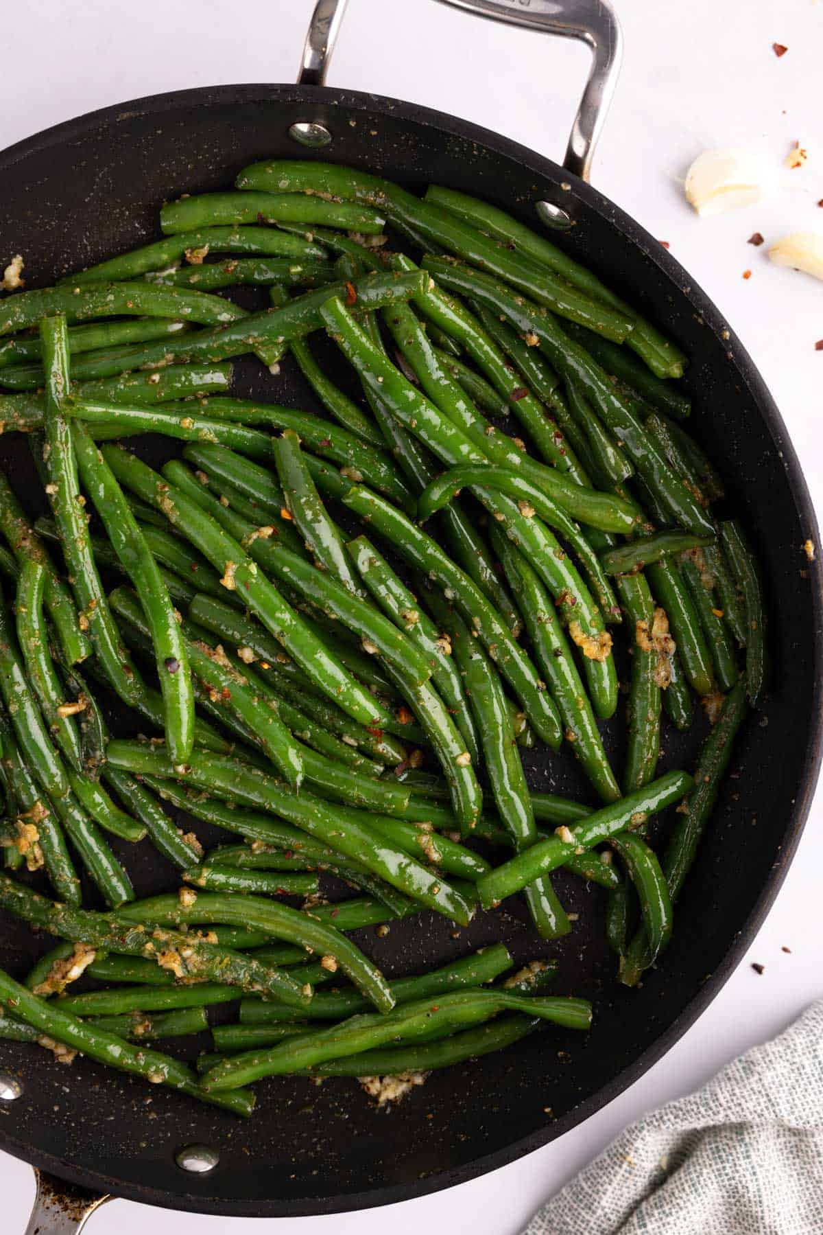 Overhead of garlic green beans in a cooking pan.